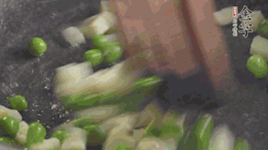 鍋中油7成熱時，入青豆、筍丁翻炒，然后加糯米飯加鹽均勻翻炒。