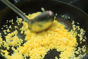 大火加熱炒鍋，再入油，燒到四至五成熱時(shí)倒入雞蛋液，在未凝結(jié)之前，加米飯煸炒，不停翻炒并用鍋鏟將成塊的米飯碾開、撥散。