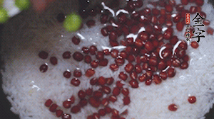 將炒好的食材和大米、紅豆一起放進(jìn)電飯鍋煮。