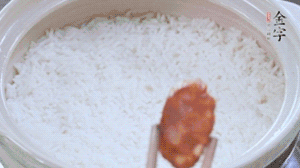 煮開(kāi)后轉(zhuǎn)小火，當(dāng)米飯出現(xiàn)小孔時(shí)，鋪上金字麻辣香腸。