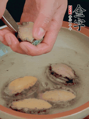 鮑魚加鹽、清水浸泡，用勺子挖出鮑魚肉。
