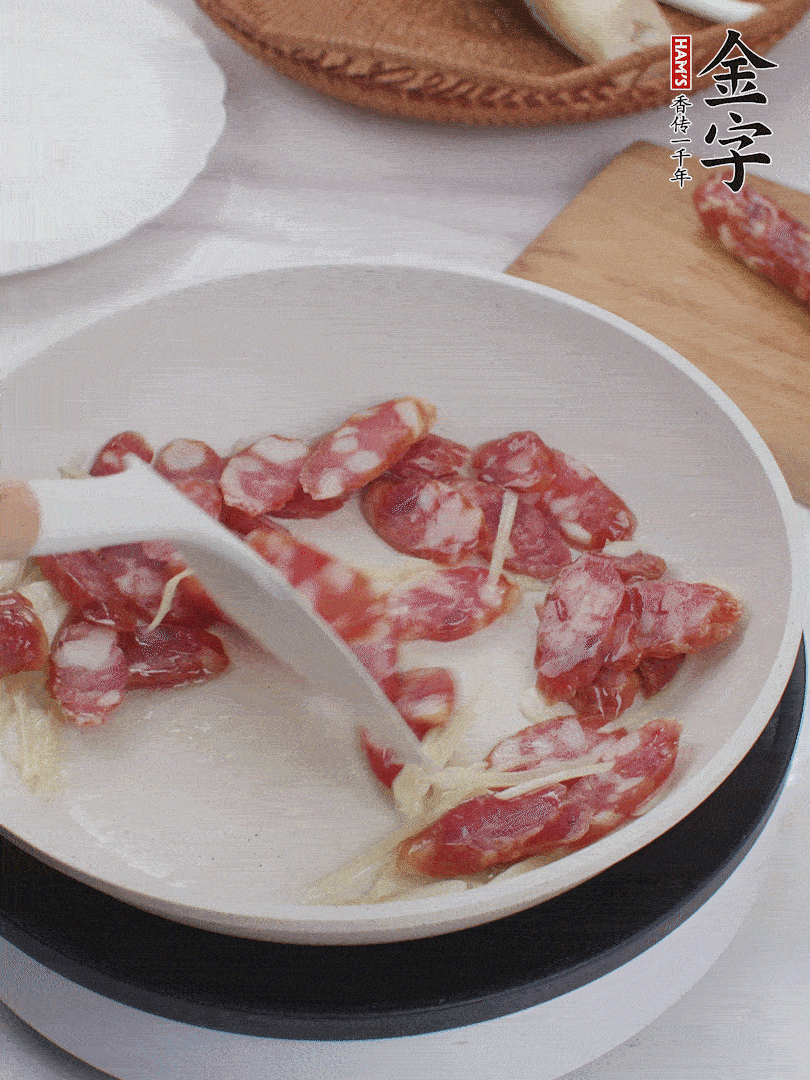 油溫3成熱時(shí)，下姜絲、蒜片、香腸炒出油脂。