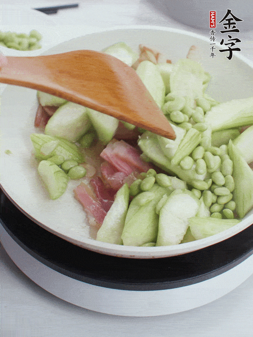 依次下絲瓜、青豆翻炒，炒至絲瓜打蔫縮小。