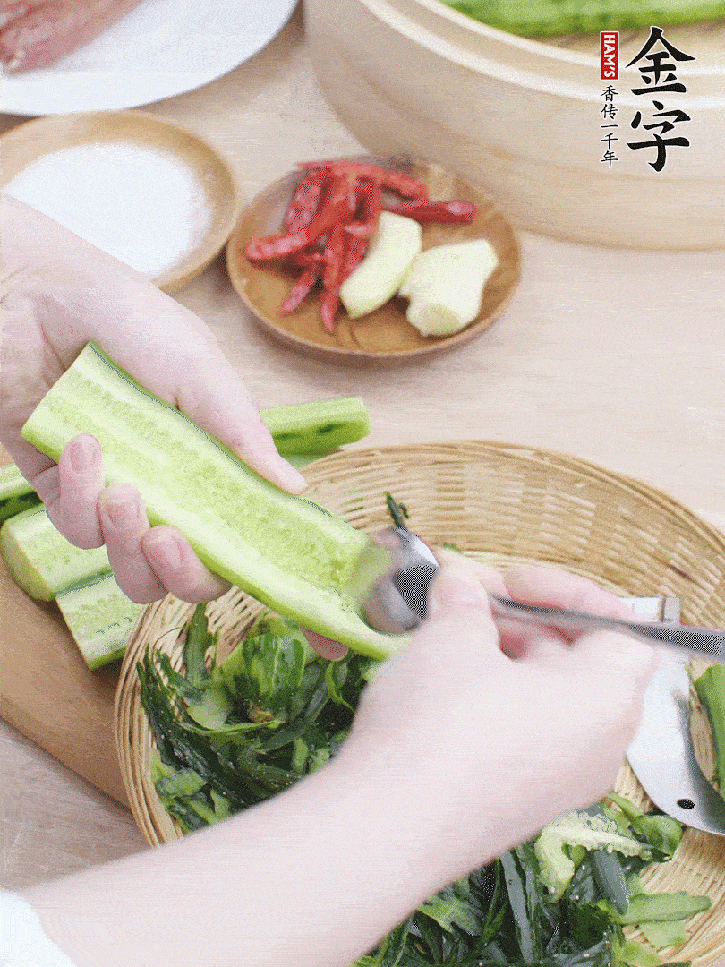 黃瓜削皮，對(duì)半切開，勺子挖去內(nèi)瓤，斜刀切片。青蒜斜刀切段。