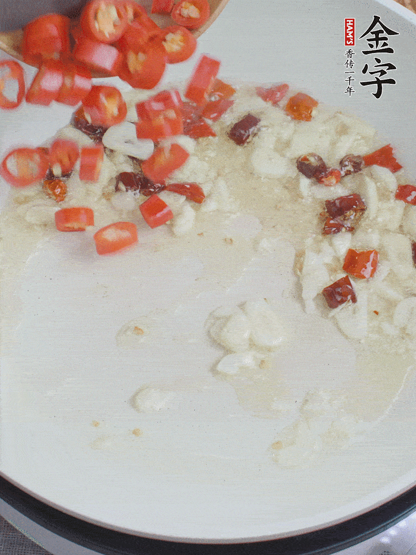 油6成熱，下蒜末、干紅辣椒煸炒，出香味后再放美人椒、香腸。