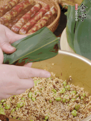 粽葉往下折，完全蓋住，兩側(cè)捏緊。