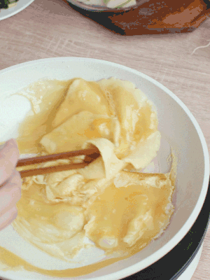 油6成熱時，下雞蛋液，邊緣凝固時翻拌成塊狀。