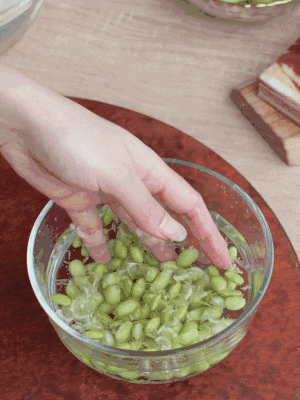 青豆剝殼，搓去外衣。