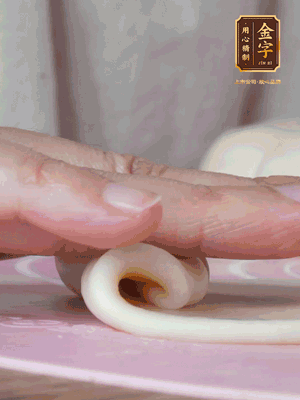 做面劑 油皮按扁，中間包入一個(gè)油酥，邊緣收緊捏死。包好的面劑按扁，用搟面杖搟壓成橢圓形。從底部向上卷成筒狀，用保鮮膜蓋好松弛15分鐘，再把筒狀縱向搟壓成長條狀。再卷一次，松弛20分鐘