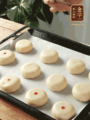 收口向下放在案板上，輕輕將月餅坯按扁，用筷子點(diǎn)紅點(diǎn)做裝飾