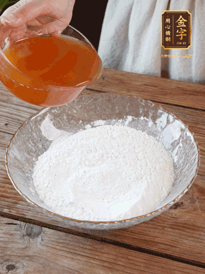 轉(zhuǎn)化糖漿、枧水、花生油攪拌均勻，加入面粉混合，醒發(fā)2小時(shí)。捏成23g一個(gè)的小球