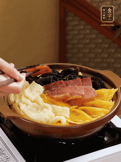 砂鍋底部鋪上娃娃菜，依次擺上肉皮、蛋餃、黑木耳、火腿